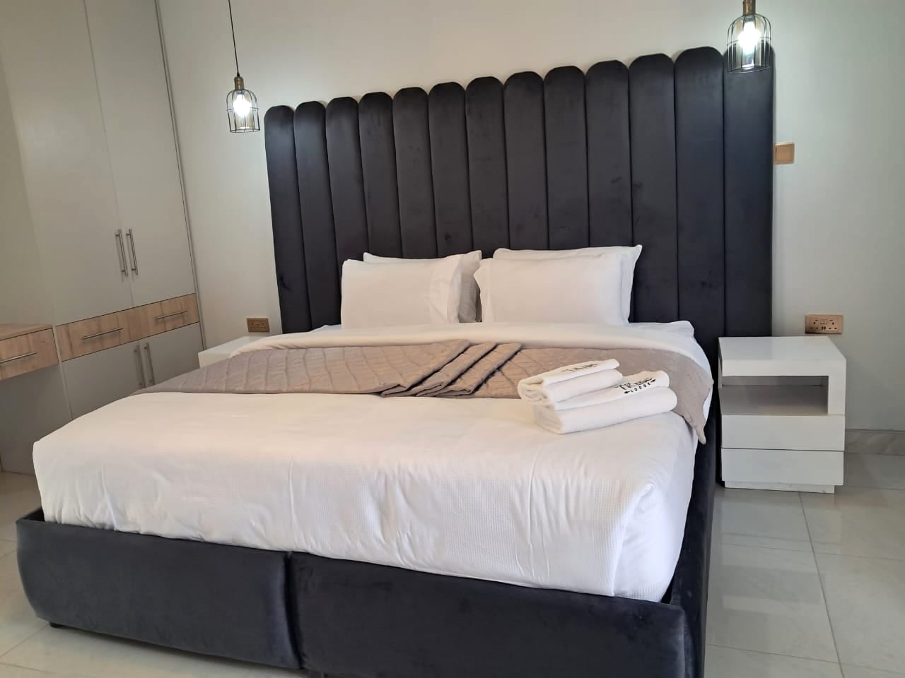Onyx Suite — black velvet feature headboard, bright modern interior